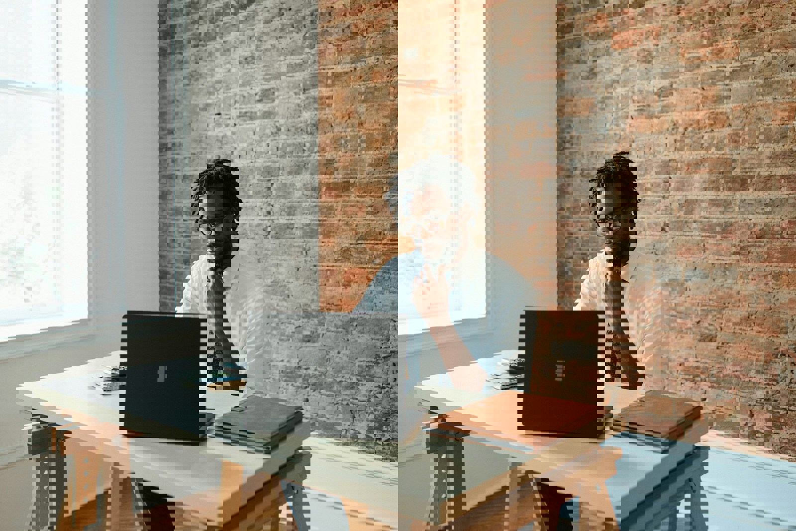 A man sat at a desk looking at a laptop