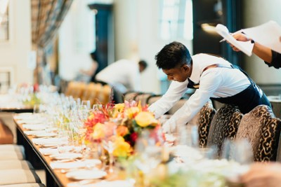 A waiter setting up a table in a restaurant